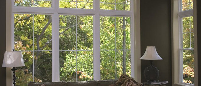 interior with couch flanked by lamps looking out of window into trees