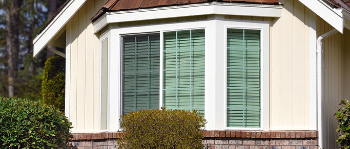 exterior view of bay window of tan and brick house
